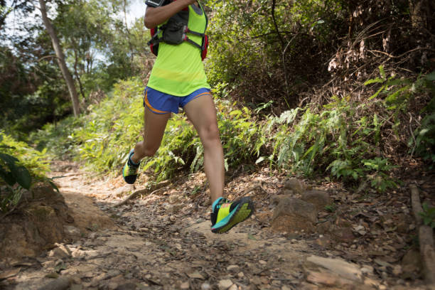 istock Young woman trail runner running on tropical forest trail 1055009776