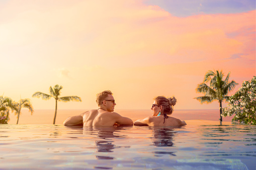 Feliz pareja en luna de miel en piscina de hotel de lujo photo