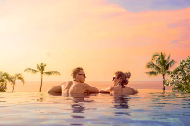 Happy couple on honeymoon in luxury hotel pool Happy couple enjoying honeymoon in luxury hotel pool exclusive travel stock pictures, royalty-free photos & images