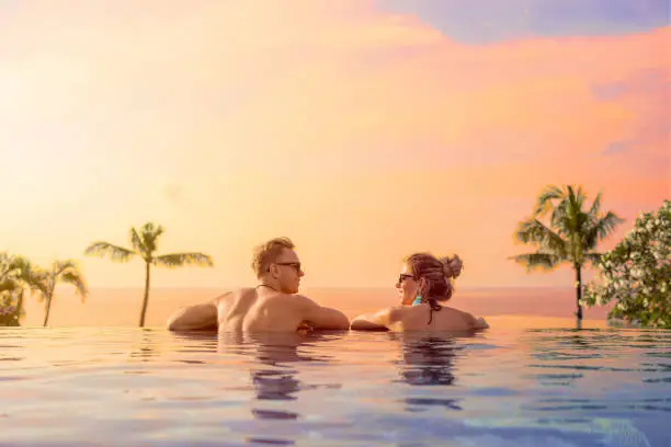 Photo of Happy couple on honeymoon in luxury hotel pool