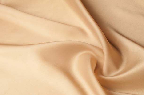 istock Texture background of fabric. Beige fabric. Silk fabric wallpaper texture background pattern in sepia pastel yellow cream beige tint: Lovely natural silk textured textile 1055010040