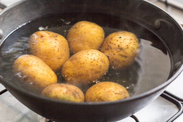 istock Potatoes boiling in a saucepan on a gas hob 1055010278