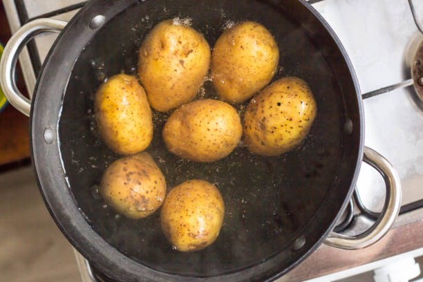 istock Potatoes boiling in a saucepan on a gas hob 1055010280