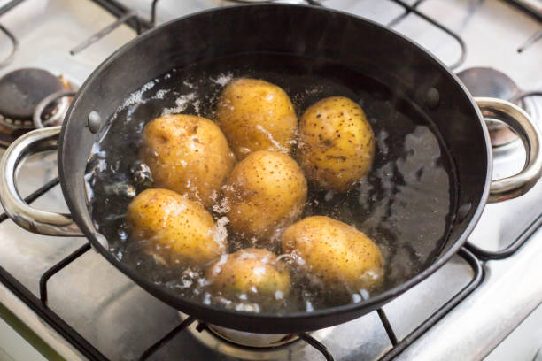 istock Potatoes boiling in a saucepan on a gas hob 1055010290