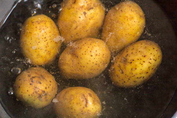 istock Potatoes boiling in a saucepan on a gas hob 1055010336