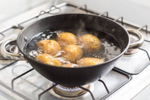 istock Potatoes boiling in a saucepan on a gas hob 1055010338