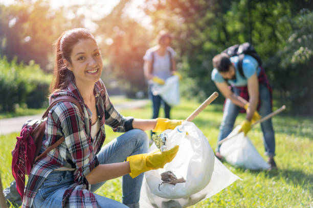 istock Young woman cleaning plastic garbage in the park 1055014974