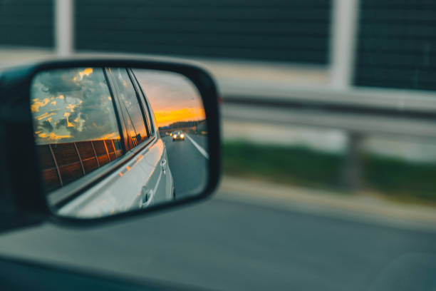 istock car on highway. sunset in car mirror reflection 1055015590