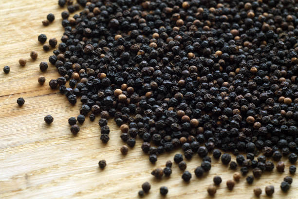 istock Black pepper close-up on wooden desk. 1055016276