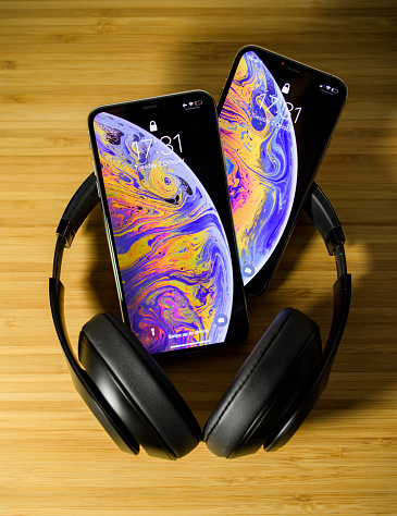PARIS, FRANCE - OCT 2, 2018: comparing the new latest iPhone Xs and Xs Max smartphones telephones after the unboxing with Beats Studio 3 professional headphones