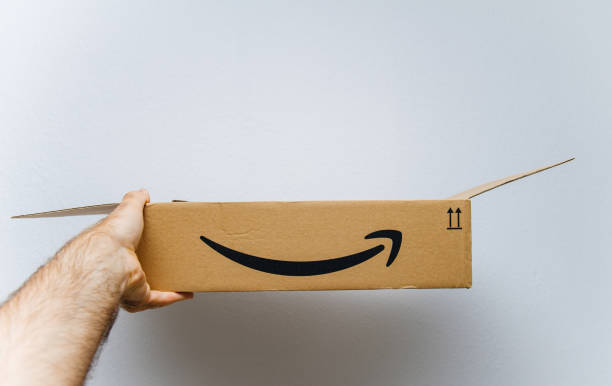 amazon-karton box vor weißem hintergrund in der hand - amazoncom stock-fotos und bilder