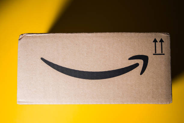 Amazon Prime cardboard box delivery yellow background PARIS, FRANCE - SEP 28, 2018: Directly above view of New Amazon Cardboard box against yellow background. Amazon Prime is the online paid subscription service offered by Amazon.com web-commerce site amazon.com photos stock pictures, royalty-free photos & images