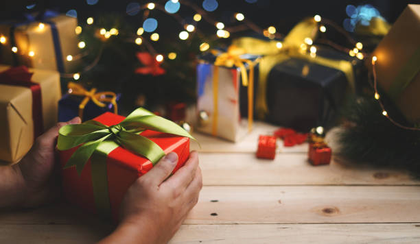 istock Hand Holding Red Green Christmas Present Gift 1055023914