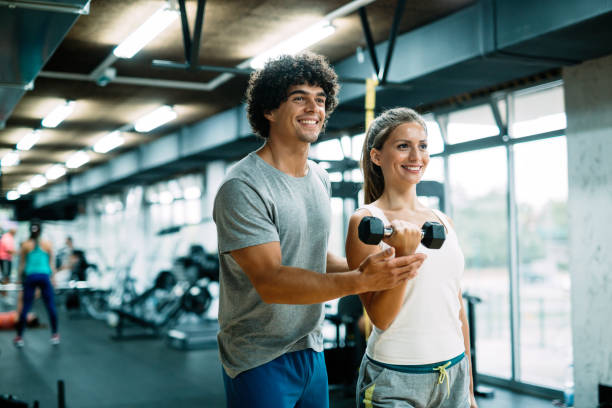istock Personal trainer helping young woman reach goals 1055027536