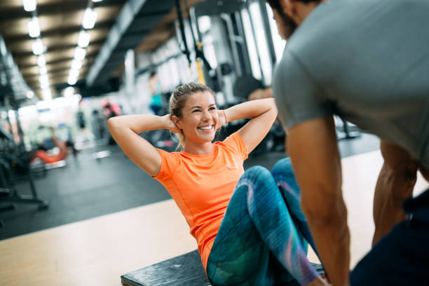 istock Personal trainer helping young woman reach goals 1055027554