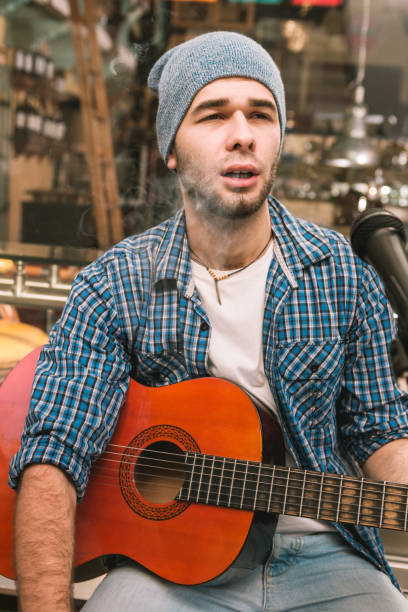 istock Musing male guitarist emitting smoke on street 1055029004