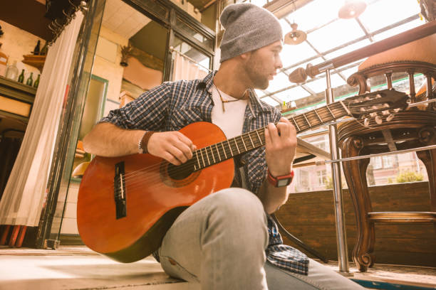 istock Distracted male guitarist fasting pick on guitar 1055029052