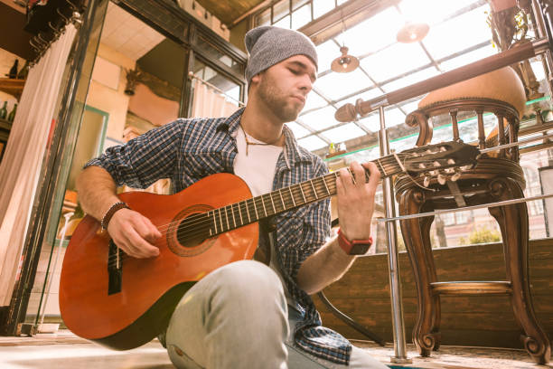 istock Attentive male guitarist challenging in playing on guitar 1055029062