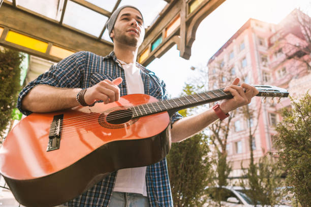 istock Thoughtful male guitarist training play on street 1055029202
