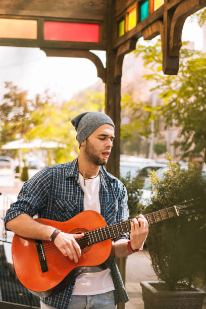 istock Appealing male guitarist pressing strings for playing 1055029216