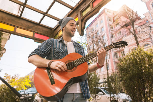 istock Attractive male guitarist strumming strings on street 1055029242