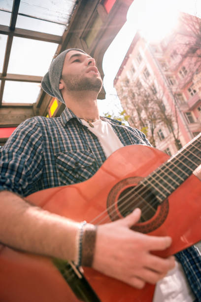 istock Handsome male guitarist developing skills on street 1055029282
