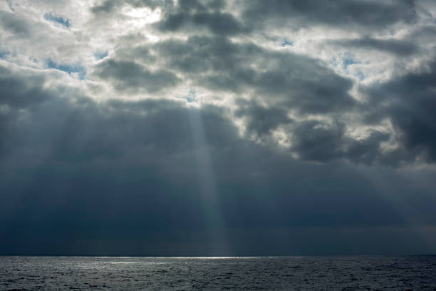 istock rays of light through the clouds falling on the sea 1055032538