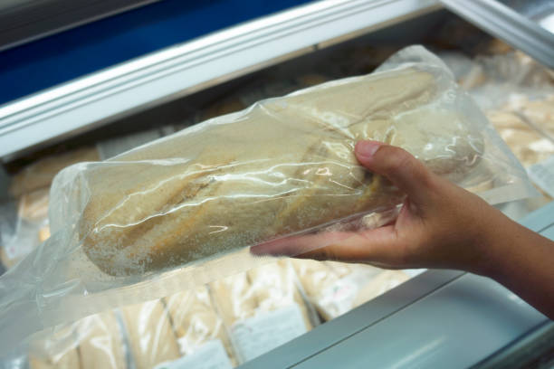 istock Hand holding Frozen loaf of bread. 1055033604
