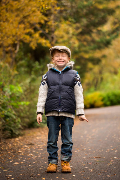 istock Boy standing on road in park during autumn 1055039984