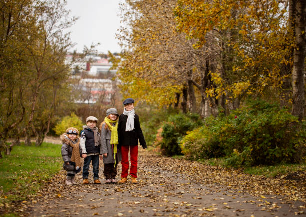 A child walks in the park against the backdrop of golden and green maple leaves and an avenue of trees in autumn. Peace, relaxation, time outdoors. active lifestyle.