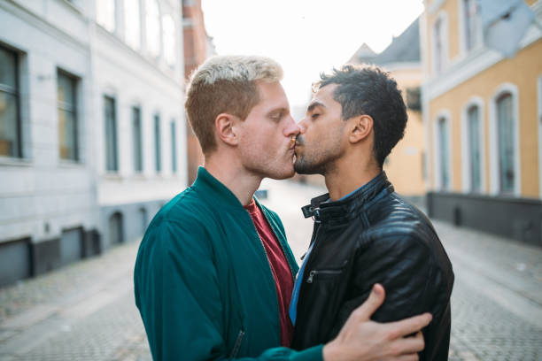 市休憩に道の真ん中でキスのゲイカップル - gay man homosexual men kissing ストックフォトと画像