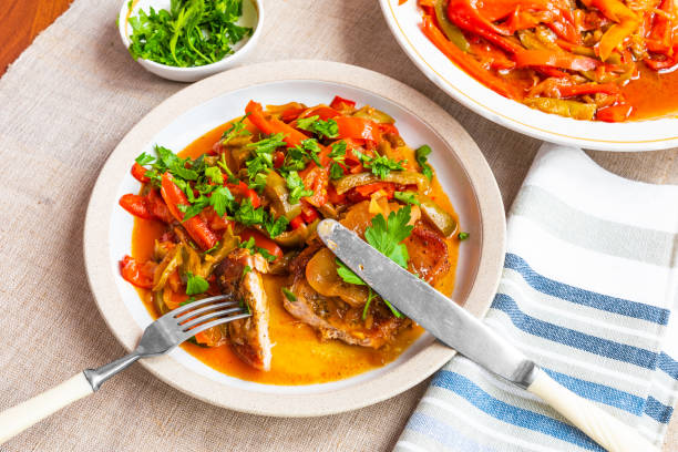 istock Healthy rustic dinner - pork chop with a side dish of stewed peppers 1055043536