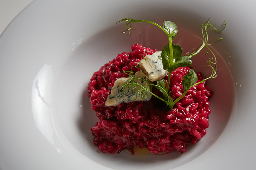 Beetroot risotto with blue cheese on a white plate