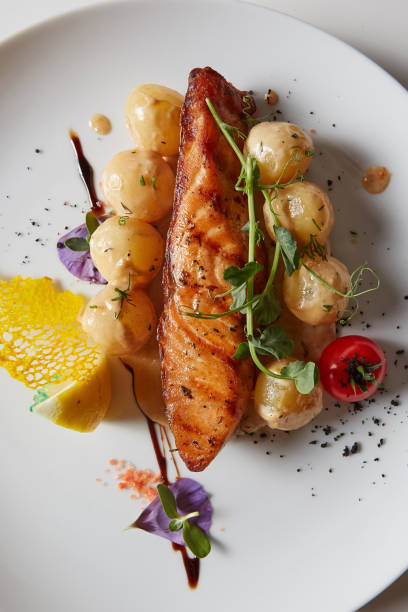 istock Roast salmon with potatoes on white plate. Shallow dof 1055044918