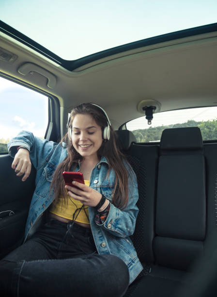 istock Young woman using headphones in car 1055047406