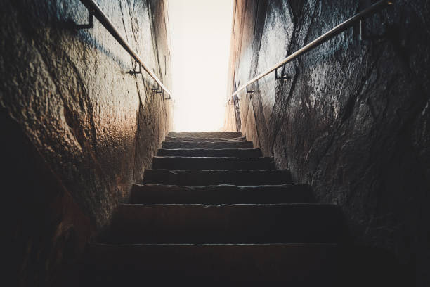 istock Old abandoned stairs going up to the light. 1055048298