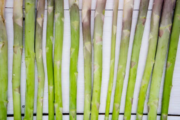 Fresh green asparagus stems on the wooden table background. Shot in the studio
