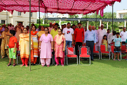 Rohtak, Haryana,  India – August 15, 2018: Group of real people from rural India standing together in the respect of National anthem during Independence day celebration event outdoor in the park.