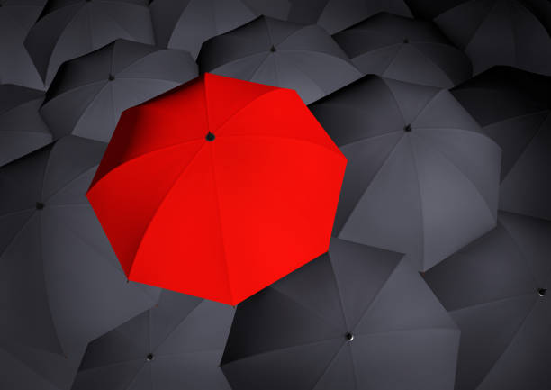 istock Top view on unique red umbrella among many dark ones. 1055056104