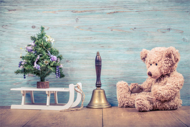 albero di capodanno, giocattolo orsacchiotto retrò, campana in bronzo e sfondo murale in legno strutturato frontale in slitta bianca. concetto di biglietto d'auguri natalizio. foto filtrata in stile instagram vintage - bell jingle christmas music foto e immagini stock