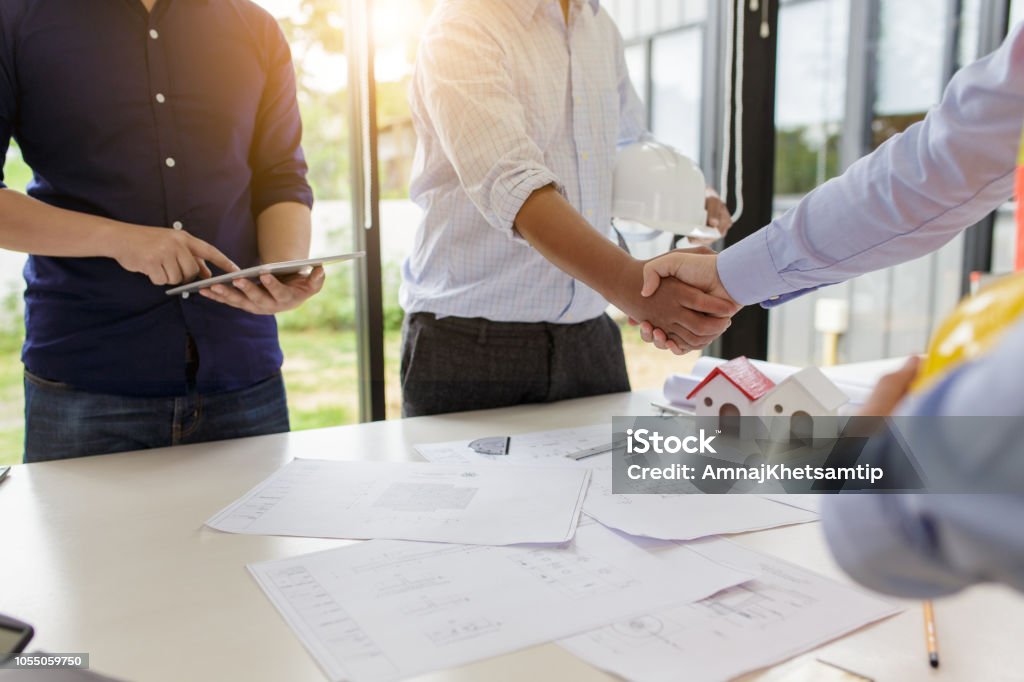 Engineers handshake at meeting. Congratulations and agreed to do the project together. Real Estate Stock Photo