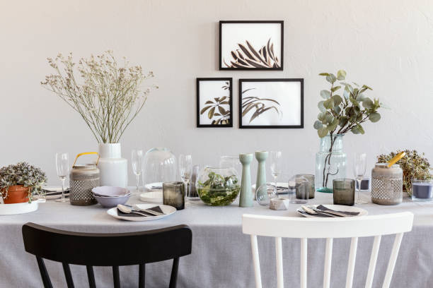 istock Black and white chair at table with tableware in grey dining room interior with posters. Real photo 1055064604