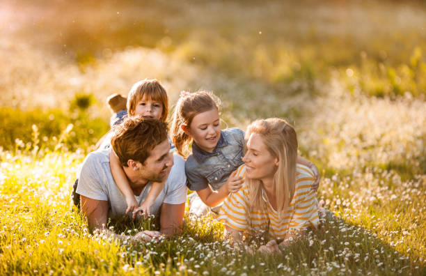 istock Happy family talking while relaxing in grass during springtime in nature. 1055065510