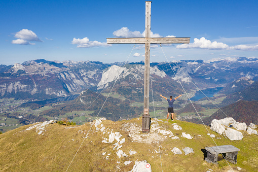 Man standing at the Zinken Summit Cross overlooking the Ausseerland, Bad Aussee, Austrian Alps, Salzkammergut, Austria. Converted from RAW.