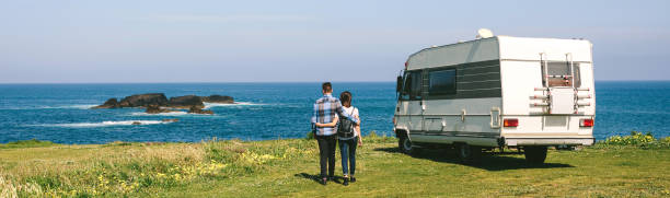 istock Couple taking a walk near the coast with a camper 1055066910