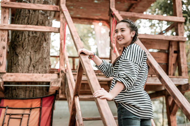 istock Positive delighted girl spending time in tree house 1055070028