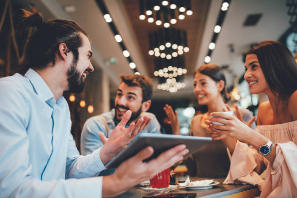 istock Group of Happy friends having with digital tablet in cafe 1055073242
