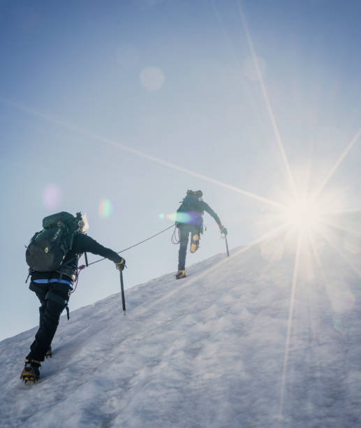 雪に覆われた斜面の登山者です。 - climbing achievement leadership adventure ストックフォトと画像