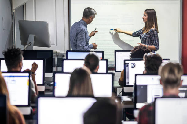 istock Female student talking to a professor about the lecture at computer class. 1055075676