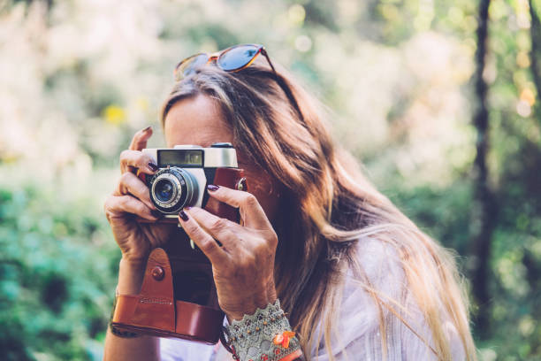 istock Mature Woman capturing an image with her Vintage camera 1055081422